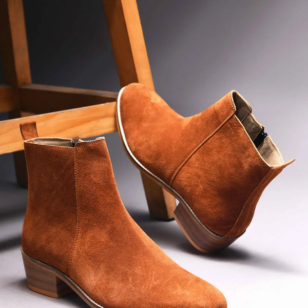 A men's luxury suede leather Chelsea boot with a cuban heel and zip side panels, in a tan color.