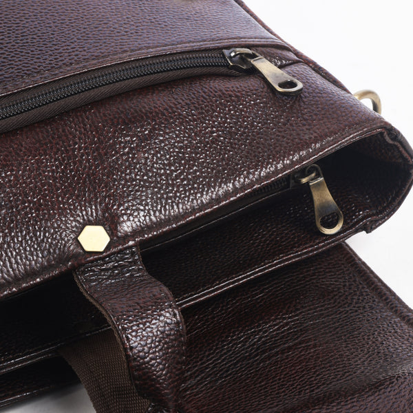 Close up of a Brown leather messenger bag with gold accents 