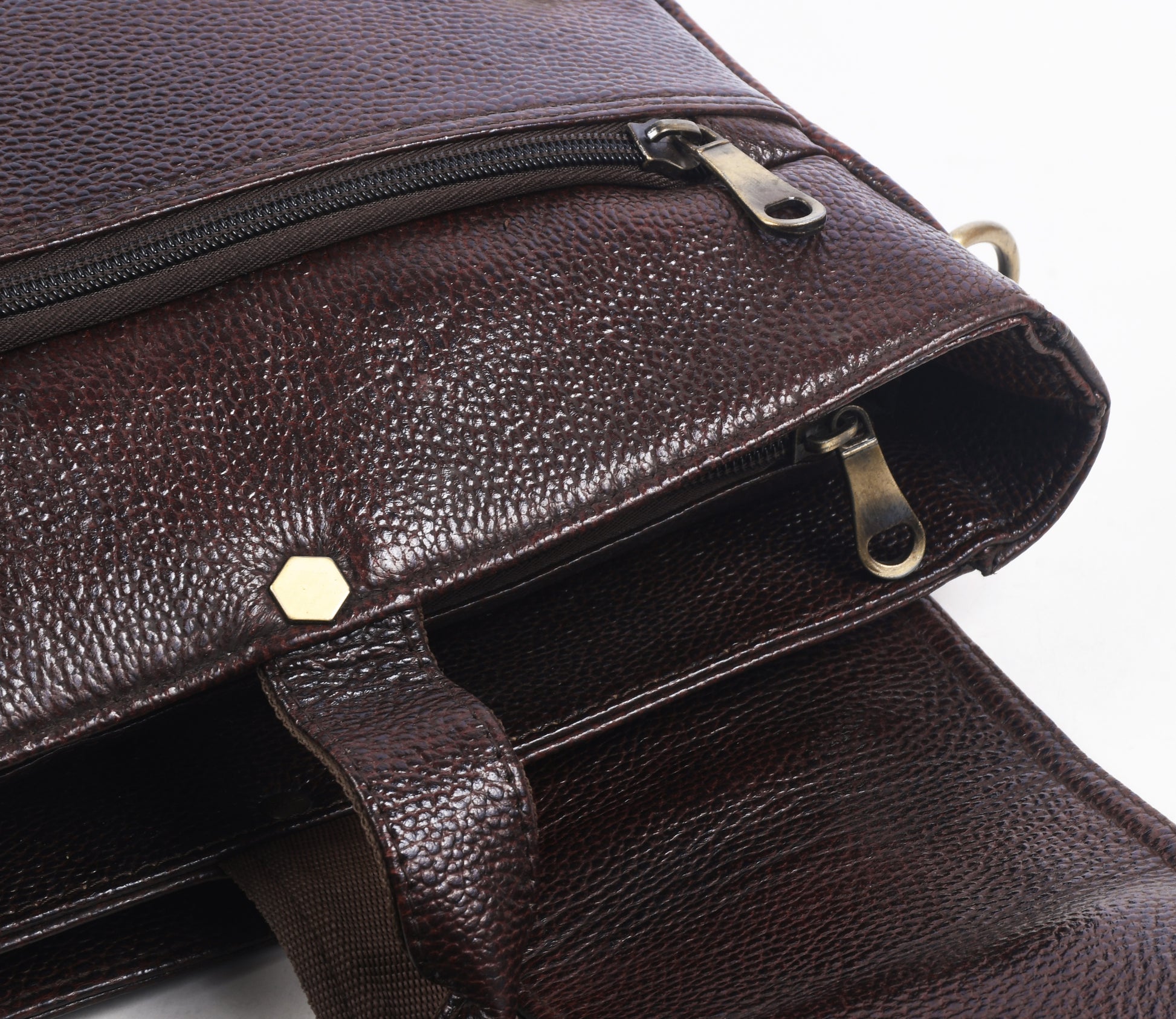 Close up of a Brown leather messenger bag with gold accents 