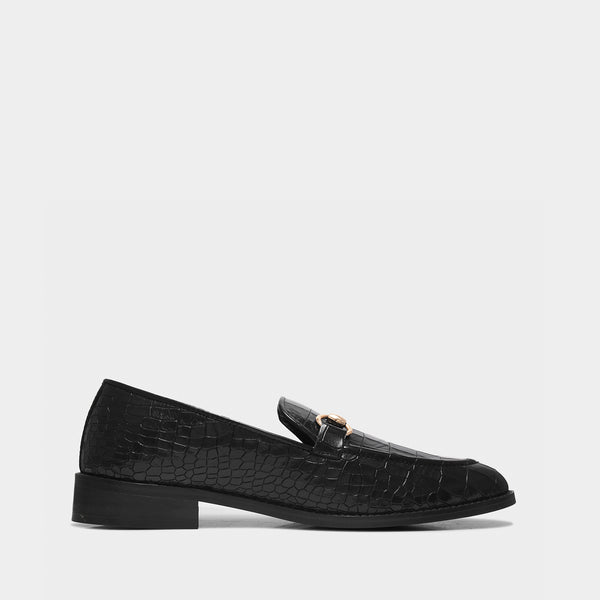 Black loafers with a textured pattern on a light gray background
