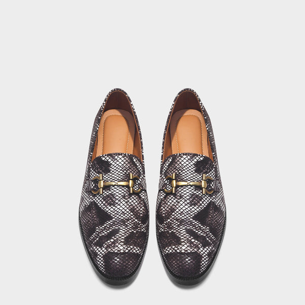 Pair of patterned loafers with gold accents on a light gray background