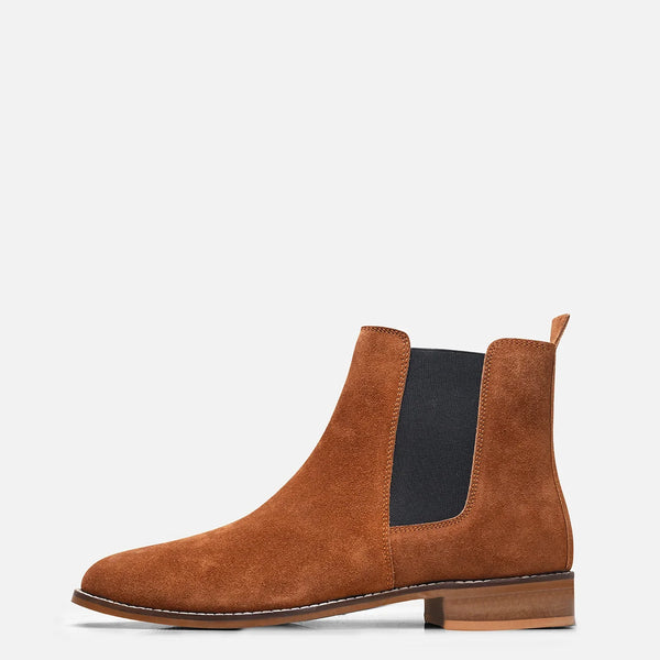 A men's luxury suede leather Chelsea boot with a mid heel and elastic side panels, in a tan color.