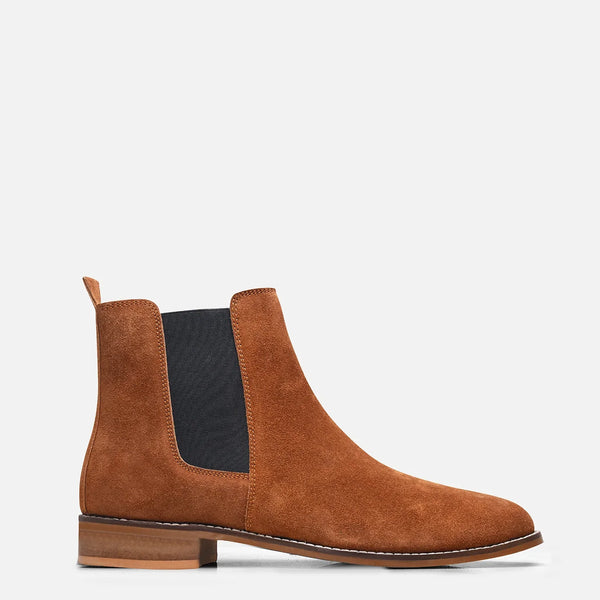 A men's luxury suede leather Chelsea boot with a mid heel and elastic side panels, in a tan color.