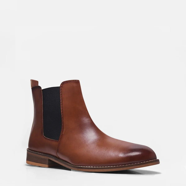 Brown leather Chelsea boot with side elastic and mid heel on a white background