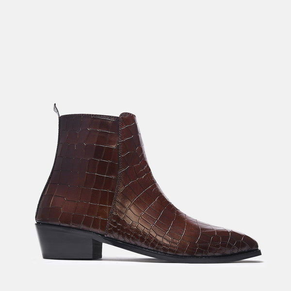 A brown leather side zip boot with a crocodile pattern and a Cuban heel.
