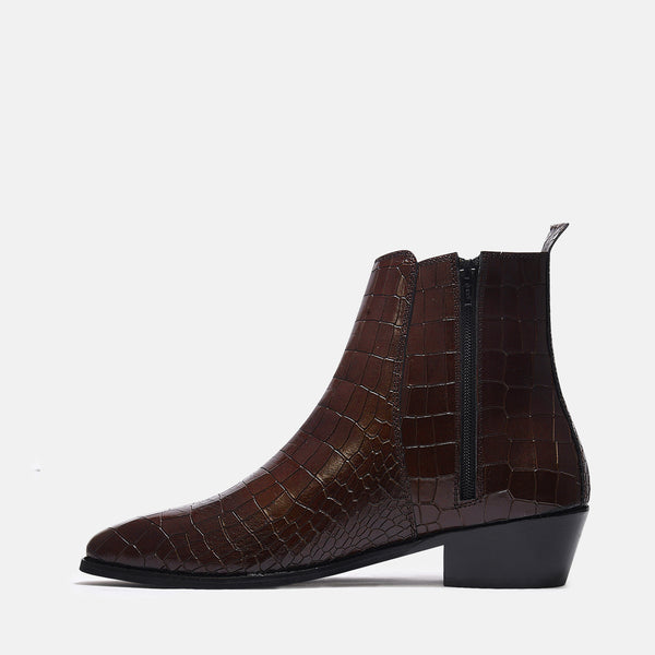 A brown leather side zip boot with a crocodile pattern and a Cuban heel.