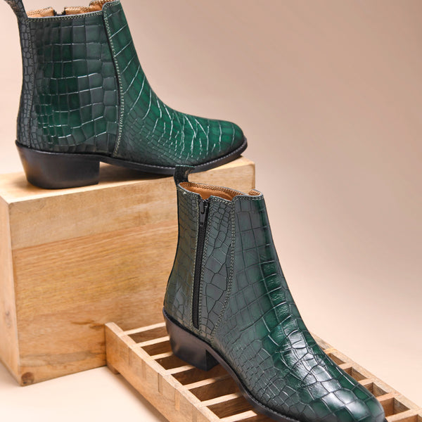 A green leather side zip boot with a crocodile pattern and a Cuban heel.