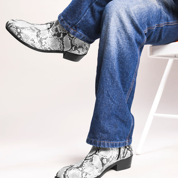 A pair of black and white snake printed leather boot with square toe and a black colour Cuban heel
