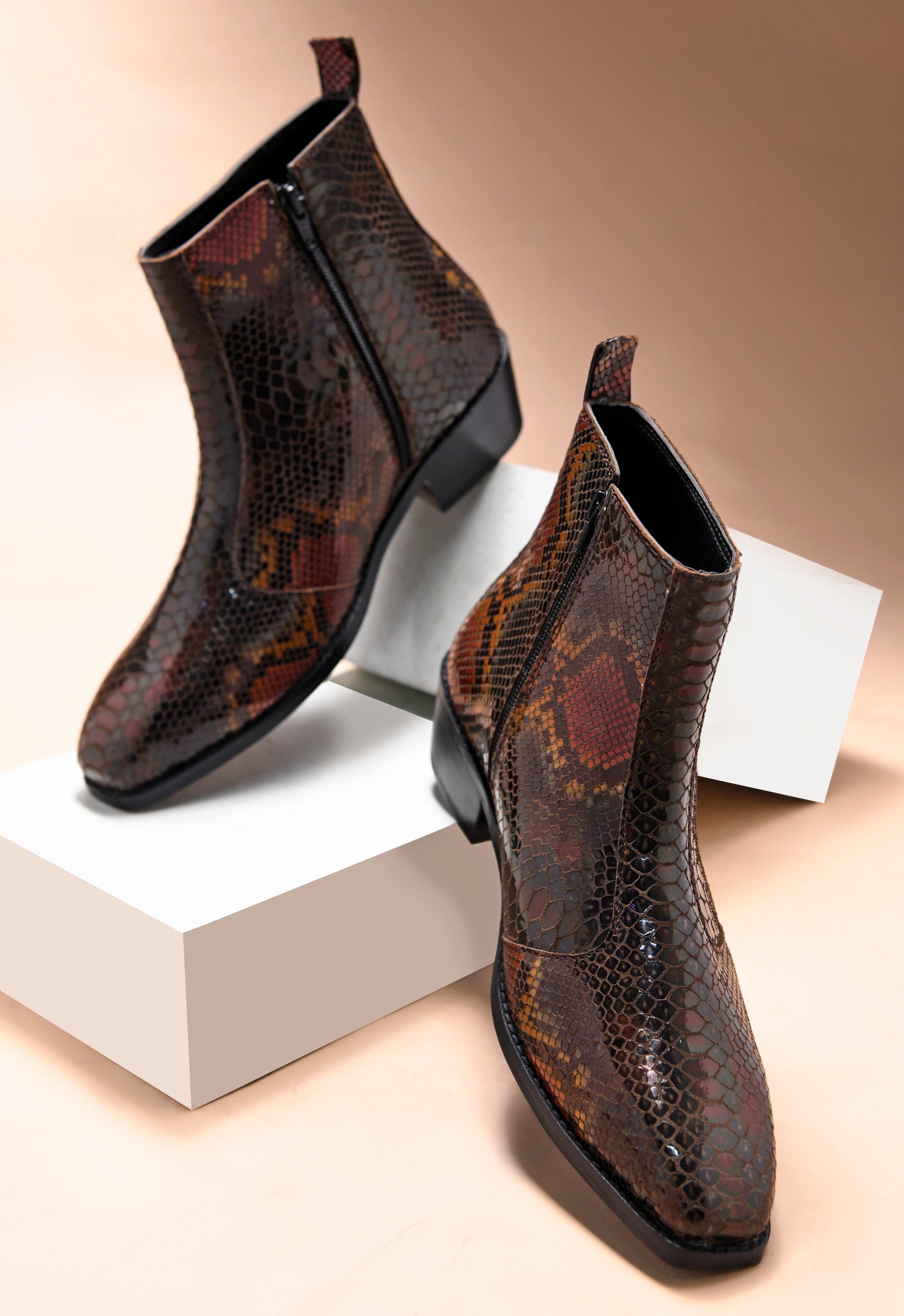 A men's leather boot with a snake-textured boot, featuring a Cuban heel and a side zipper.