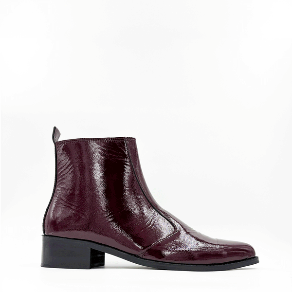 Men’s cherry red pointed-toe Chelsea boots in glossy patent leather with side zip closure, sleek and stylish luxury footwear ideal for formal and party outfits.