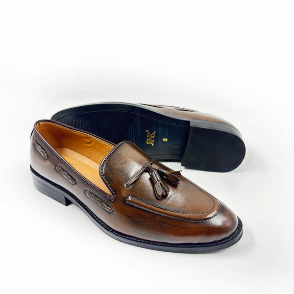 Brown leather loafer with tassel on a white background